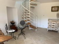 a room with a spiral staircase and a table and chairs at Gîte chez le Gaulois in Carsac-Aillac