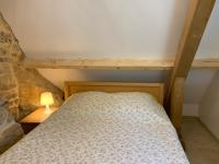 a bedroom with a bed and a lamp on a table at Gîte chez le Gaulois in Carsac-Aillac