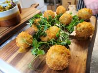 un plato de madera con algo de comida en una mesa en The Swan - A Colombo Edition Hotel, en Ely