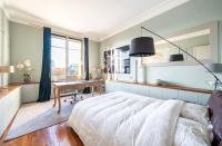 a bedroom with a bed and a desk and a window at Spacieux et élégant appartement Porte des ternes in Paris