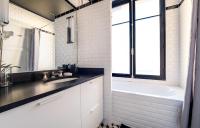 a bathroom with a sink and a tub and a window at Spacieux et élégant appartement Porte des ternes in Paris