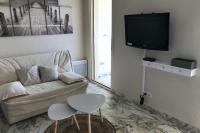 a living room with a couch and a tv at Charming Studio With Terrace And 180 Sea View in Six-Fours-les-Plages