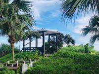 a gazebo on a hill with palm trees at Kenting Summerland Garden Resort in Eluan