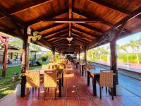 a restaurant with tables and chairs under a wooden roof at Kenting Summerland Garden Resort in Eluan