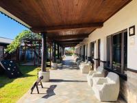 a covered walkway with white chairs and a playground at Kenting Summerland Garden Resort in Eluan