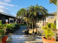 a courtyard with palm trees in front of a building at Kenting Summerland Garden Resort in Eluan