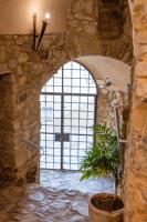 a stone hallway with a large window and a potted plant at Hotel Tugasa Castillo de Castellar in Castellar de la Frontera