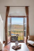 a room with a large window with a view of the ocean at Hotel Tugasa Castillo de Castellar in Castellar de la Frontera