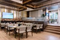 a restaurant with tables and chairs and a flat screen tv at Triss Hotel in Tirana