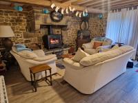 a living room with two couches and a fireplace at La Bannerie in Mesnil-Clinchamps
