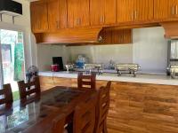 Nahas Beach Resort في Abung: مطبخ مع دواليب خشبية وطاولة طعام