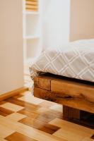 a bed with a white pillow on a wooden platform at DOUX Apartman in Odorheiu Secuiesc