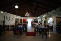 een restaurant met blauwe tafels en stoelen in een kamer bij Hosteria Casa Giralda in Baños