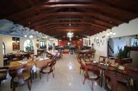 een restaurant met houten plafonds en tafels en stoelen bij Hosteria Casa Giralda in Baños