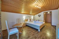 a bedroom with a bed and a table and a chair at Hotel Gamshag in Saalbach-Hinterglemm