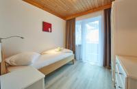 a bedroom with a bed and a large window at Hotel Gamshag in Saalbach-Hinterglemm