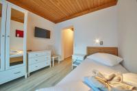 a bedroom with two beds and a dresser and a mirror at Hotel Gamshag in Saalbach-Hinterglemm