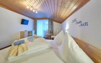 a bedroom with a large bed with white pillows at Hotel Gamshag in Saalbach-Hinterglemm