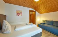a bedroom with a bed and a couch at Hotel Gamshag in Saalbach-Hinterglemm