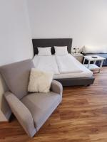 a bedroom with a bed and a couch and a chair at Apartments HAUS SCHÖN - Preise inclusive Pitztal Sommer Card in Jerzens