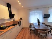 a kitchen with a table and a dining room at Apartments HAUS SCHÖN - Preise inclusive Pitztal Sommer Card in Jerzens