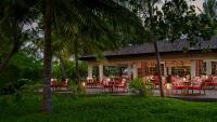 a restaurant with red tables and chairs and palm trees at Anantara Veli Maldives Resort in South Male Atoll
