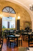 a restaurant with tables and chairs and a brick wall at Hotel Tugasa Convento San Francisco in Vejer de la Frontera