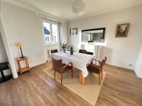 a dining room with a white table and chairs at Appartement de charme - Lorient in Lorient