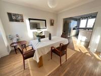 a living room with a table and chairs and a kitchen at Appartement de charme - Lorient in Lorient