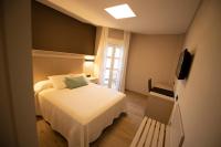 a small bedroom with a bed and a television at Hotel Diufain in Conil de la Frontera