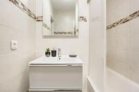 a white bathroom with a sink and a bath tub at Appart spacieux près de la Seine in Sartrouville