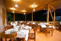 a restaurant with tables and chairs with white table cloth at Gorilla Leisure Lodge in Kisoro