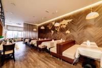 ein Restaurant mit Tischen, Stühlen und einer Wand in der Unterkunft Chagala Hotel Aksai in Aksay