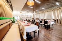 ein Esszimmer mit weißen Tischen und Stühlen in der Unterkunft Chagala Hotel Aksai in Aksay