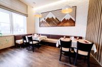 ein Esszimmer mit Tischen und Stühlen und einem Gemälde an der Wand in der Unterkunft Chagala Hotel Aksai in Aksay