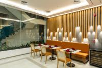 un restaurante con una mesa larga y sillas en Odin Hotel Quy Nhon, en Quy Nhon