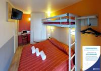 a bedroom with a bunk bed with a red bedspread at Premiere Classe Cambrai Proville in Cambrai