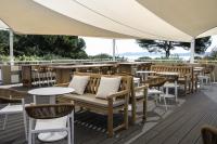 a restaurant with tables and chairs and a large umbrella at Belambra Clubs Presqu&#39;île De Giens - les Criques in Hyères