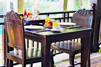 uma mesa de madeira com duas cadeiras e uma mesa com comida em Yantarasri Resort em Chiang Mai