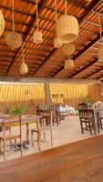 - un coin repas avec des tables, des chaises et des lumières dans l'établissement Pousada Do Vozinho, à Touros