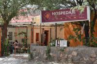 una señal para un restaurante hospedale frente a un edificio en La Enramada, en Amaicha del Valle
