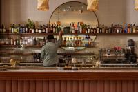 a man standing behind a bar in a restaurant at The Hoxton, Downtown LA in Los Angeles