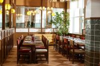 a restaurant with wooden tables and chairs and windows at The Hoxton, Downtown LA in Los Angeles