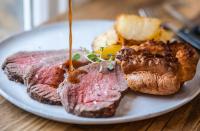 Pohorje Village Wellbeing Resort - Forest Apartments Videc في هوكو بوهوجري: طبق من الطعام مع لحم وخبز على طاولة