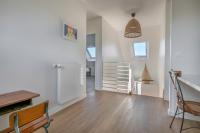 a living room with a wooden table and a staircase at Lumineuse et accueillante maison pour 8 personnes in Sarzeau