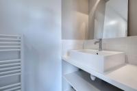 a white bathroom with a sink and a mirror at Lumineuse et accueillante maison pour 8 personnes in Sarzeau