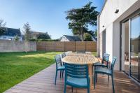 a wooden table and chairs on a deck at Lumineuse et accueillante maison pour 8 personnes in Sarzeau