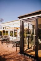a patio with tables and chairs and umbrellas at The Farmhouse at Redcoats in Stevenage