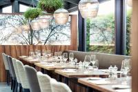 a row of tables in a restaurant with wine glasses at Hotel UTO KULM car-free hideaway in Zurich in Zürich