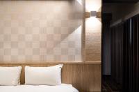 a bed with white pillows and a light above it at Global Traveler Hotel in Kaohsiung